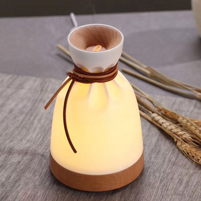 Decorative lamp with wooden base and white top on a gray surface