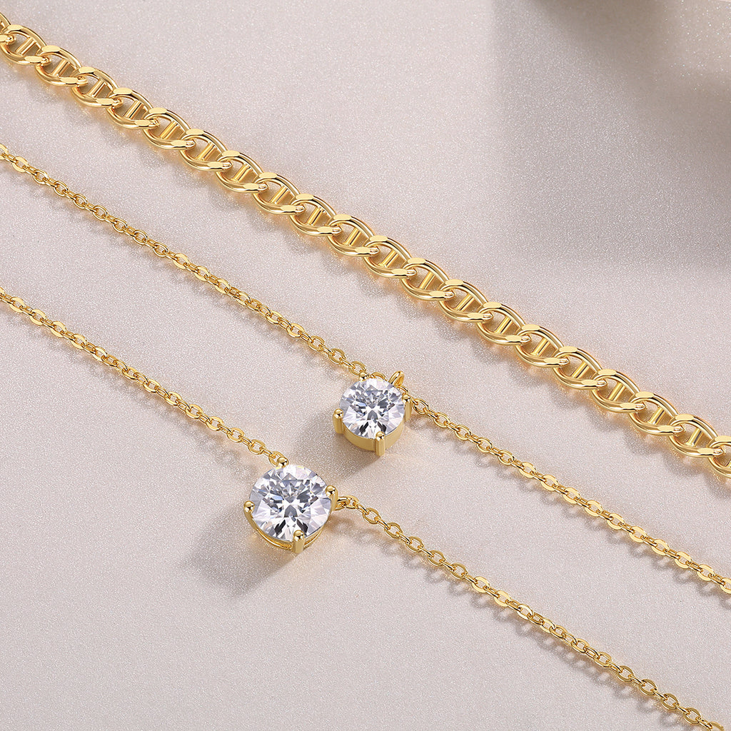 Two gold necklaces with diamond pendants on a light beige background