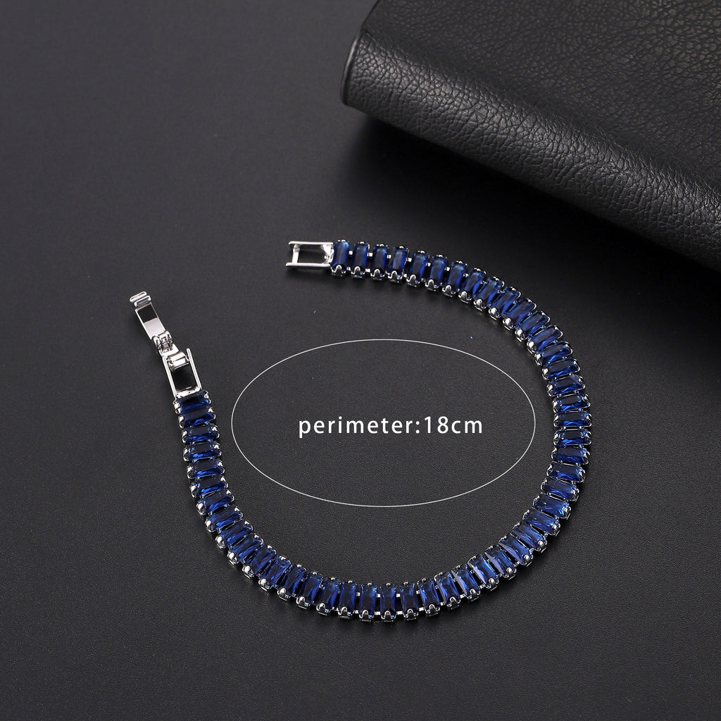 Blue beaded bracelet with silver clasps on a dark surface
