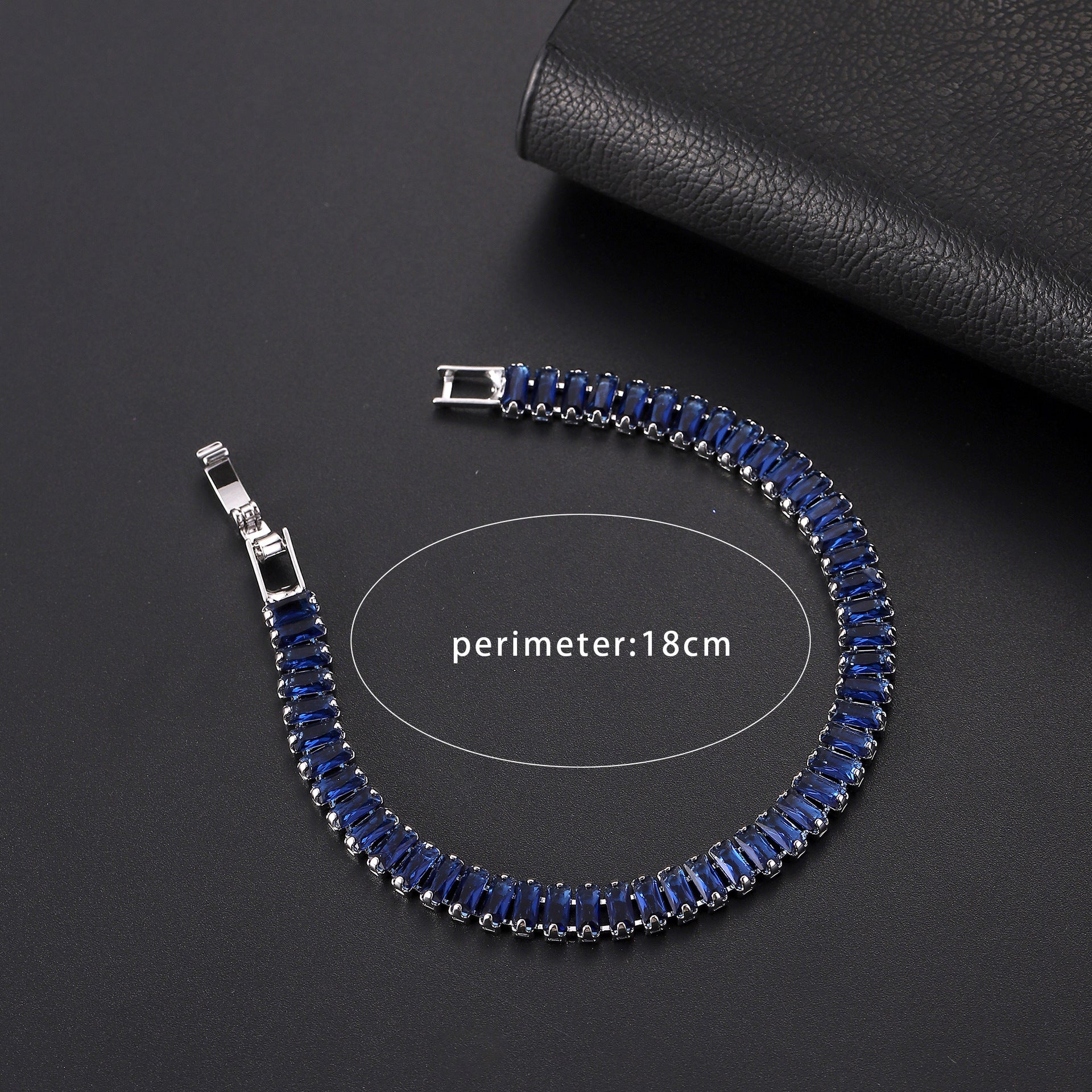 Blue beaded bracelet with silver clasps on a dark surface