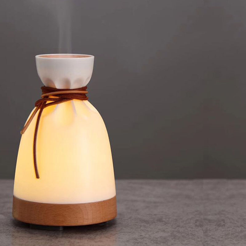 Decorative lamp with wooden base and white top on a dark background