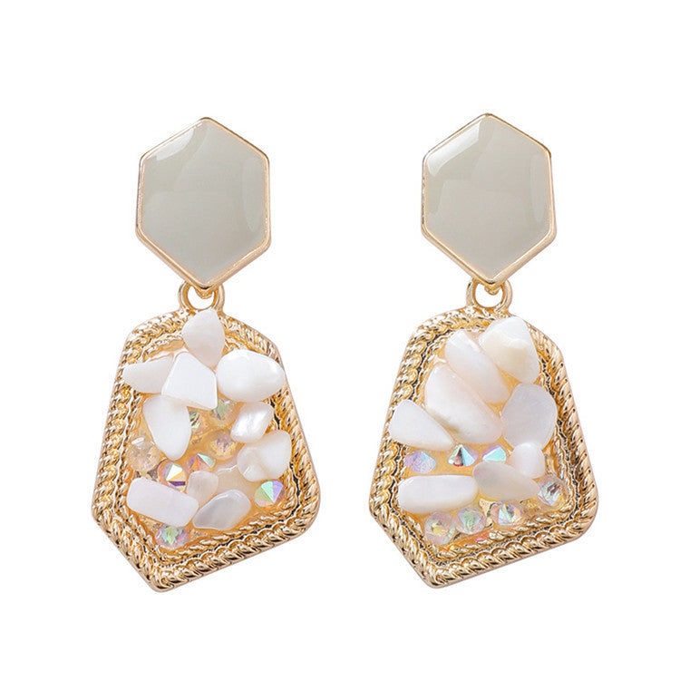 Gold and white stone earrings on a white background