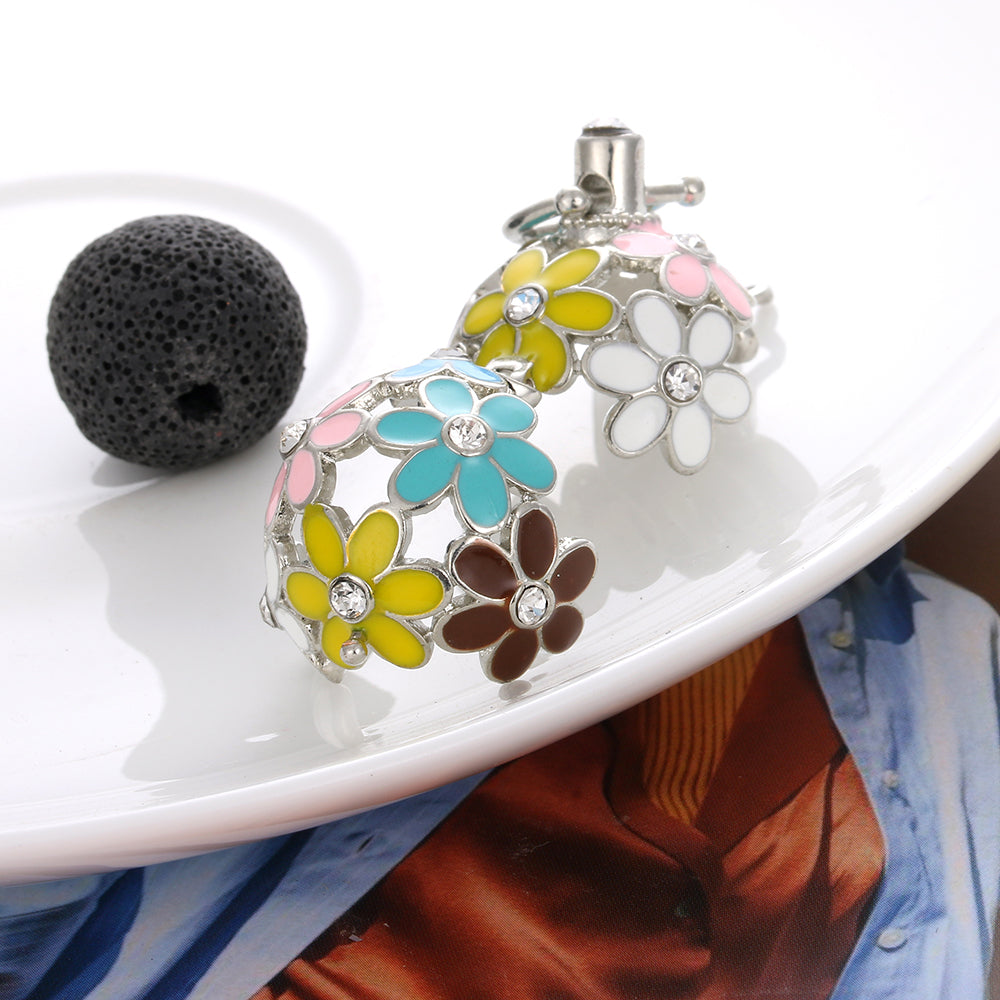 Colorful flower-shaped diffusers on a white plate with a black stone and blue fabric.