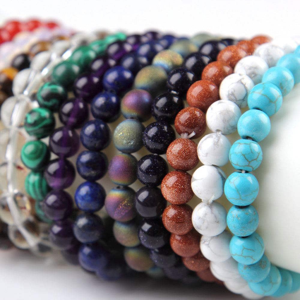 Stack of colorful beaded bracelets on a white surface