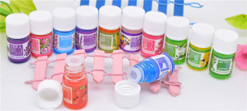 Set of small bottles with colorful labels on a white surface