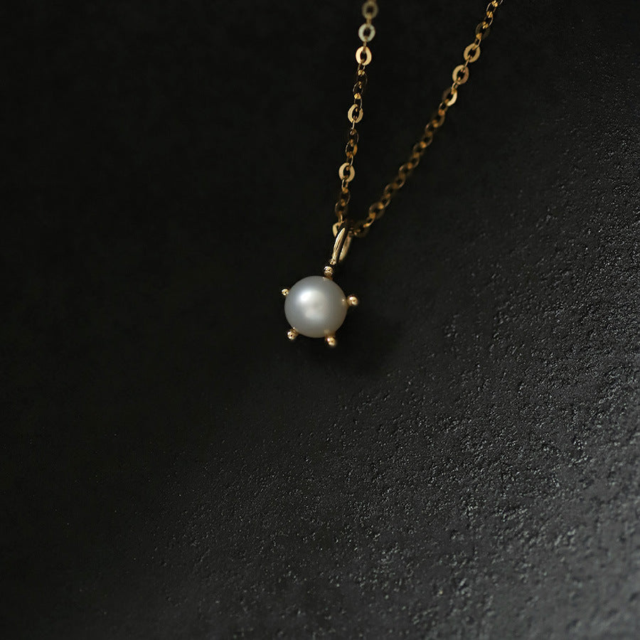 Pearl necklace with gold chain on a dark background