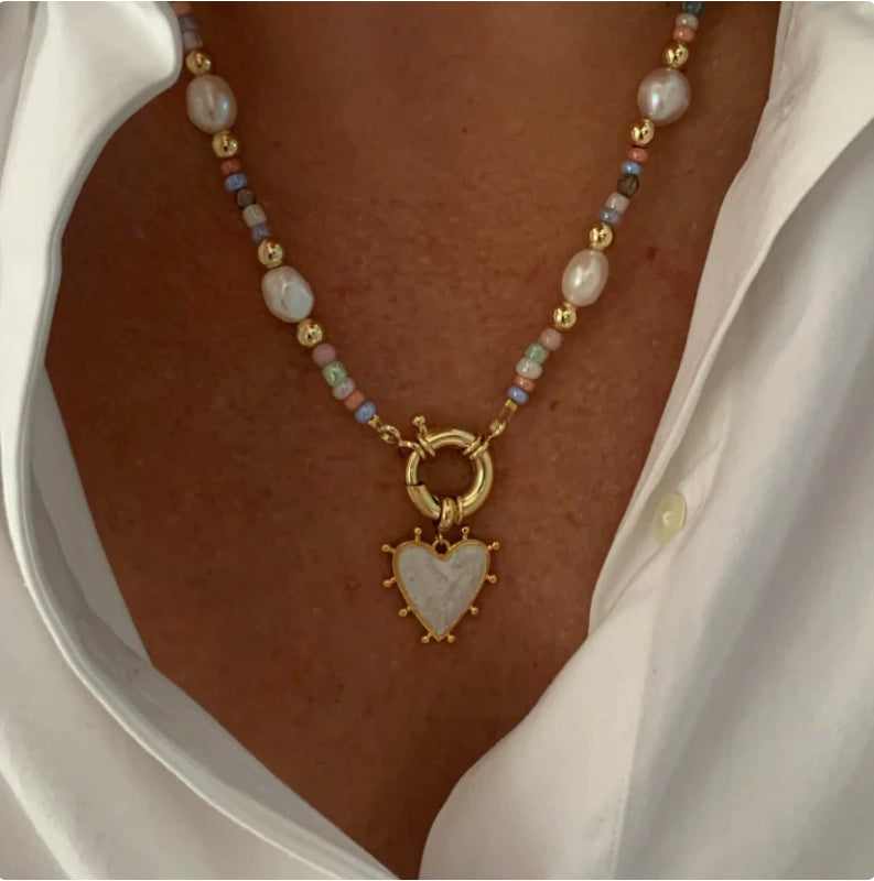 Necklace with a heart-shaped pendant worn by a person, close-up view.