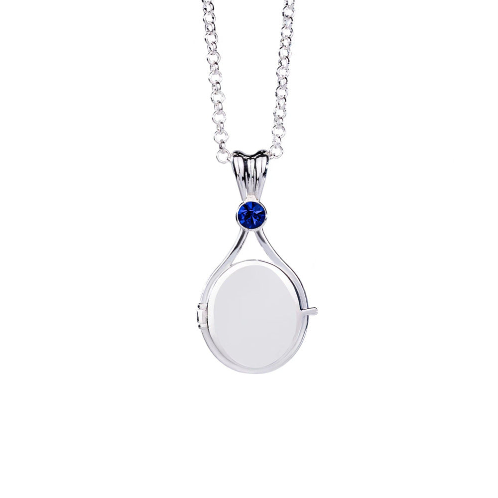Silver necklace with a round pendant featuring a blue gemstone on a white background