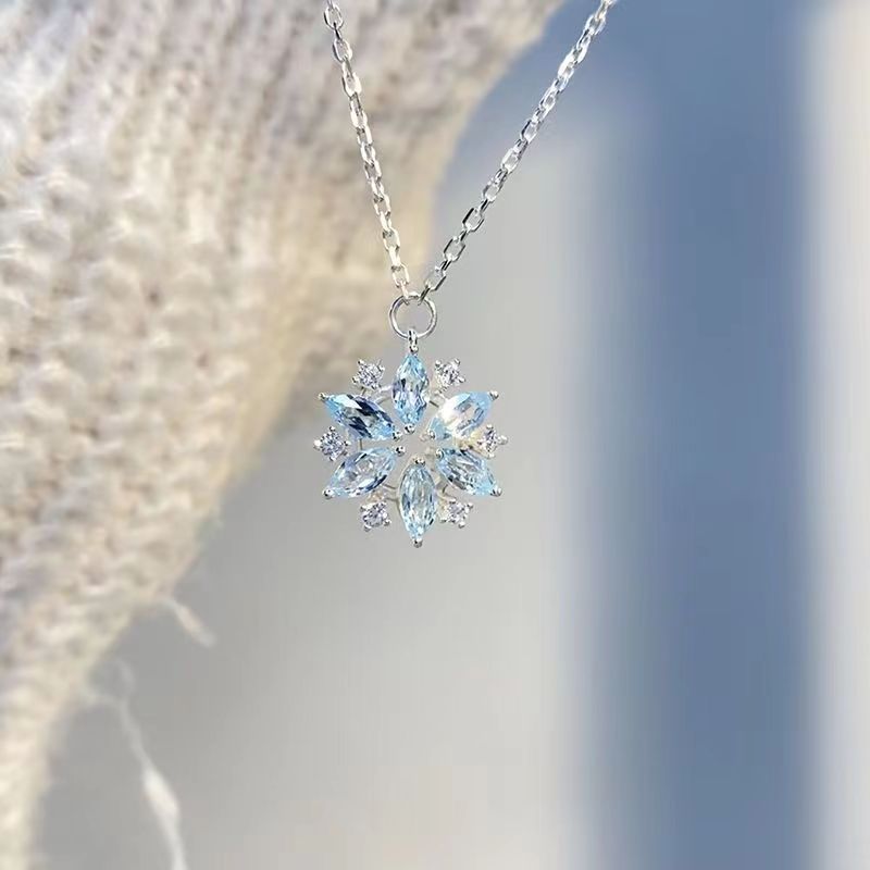 Snowflake-shaped pendant necklace on a blurred background