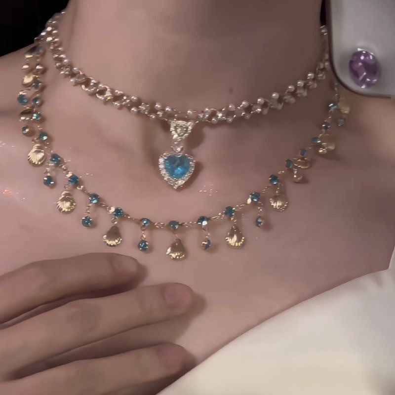Necklace with heart-shaped blue gemstone on a mannequin