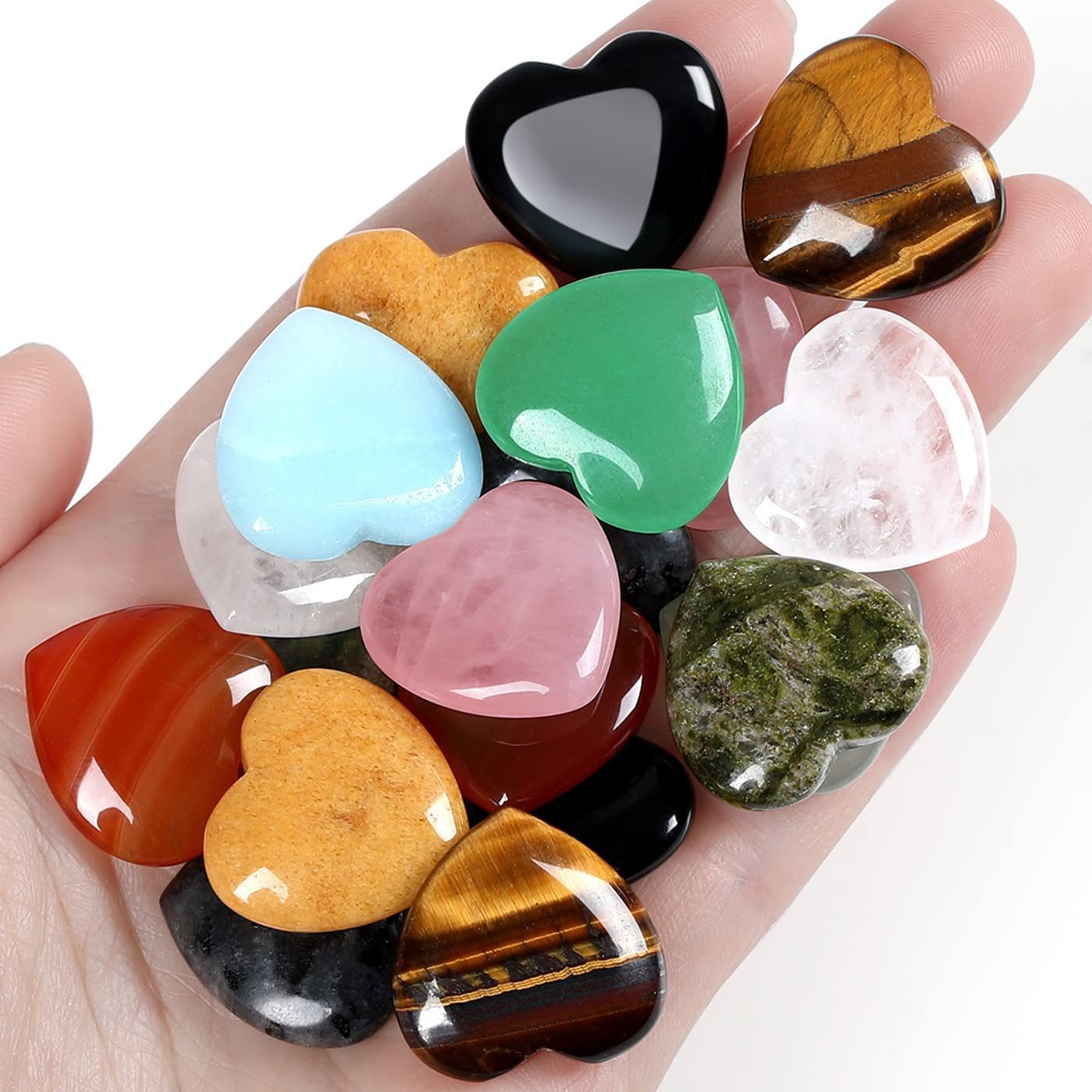 Hand holding a collection of heart-shaped gemstones in various colors and patterns.