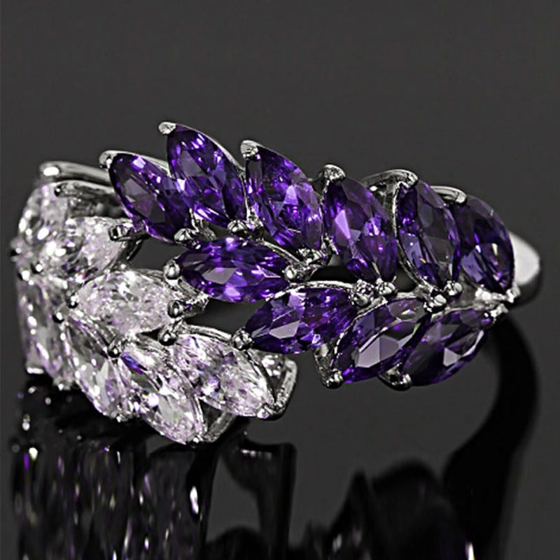 Ring with purple and clear gemstones on a dark background