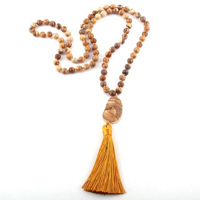 Necklace with brown beads and a yellow tassel on a white background