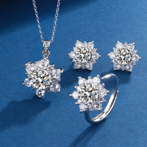 Silver jewelry set with floral designs on a blue background