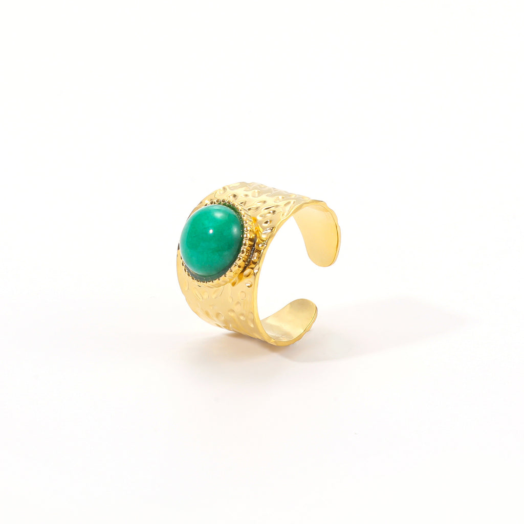 Gold ring with a green gemstone on a white background