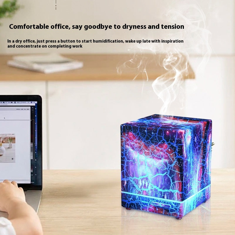 Cube humidifier emitting steam in an office setting with a laptop on a desk.