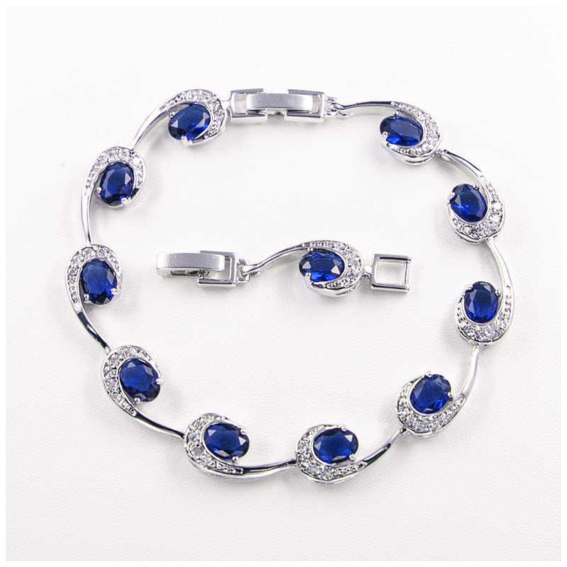 Silver bracelet with blue gemstones on a white background