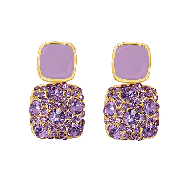 Purple earrings with gold accents on a white background
