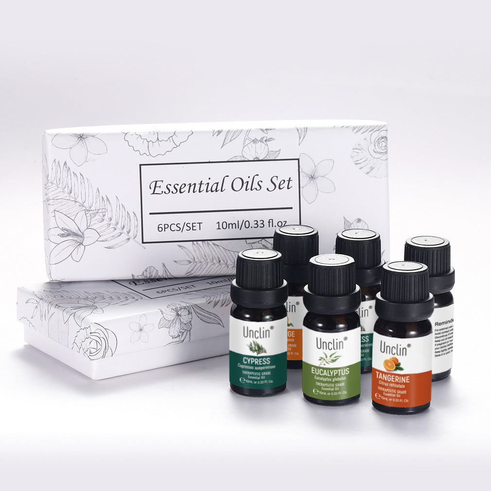 Set of essential oil bottles with a branded box on a white background