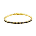 Gold bracelet with black stones on a white background