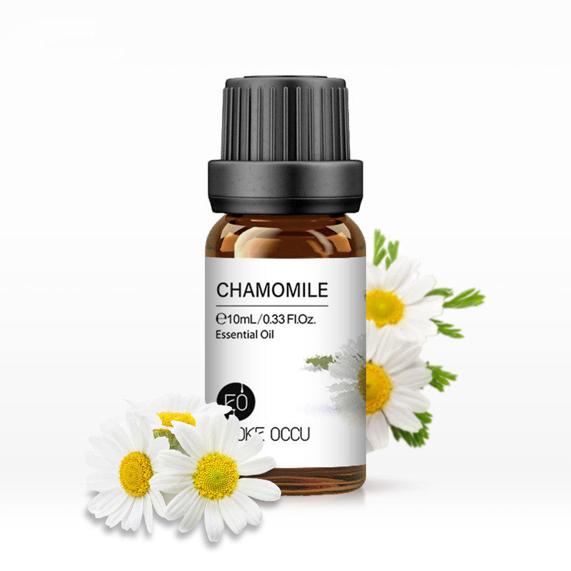 Chamomile essential oil bottle with flowers on a white background