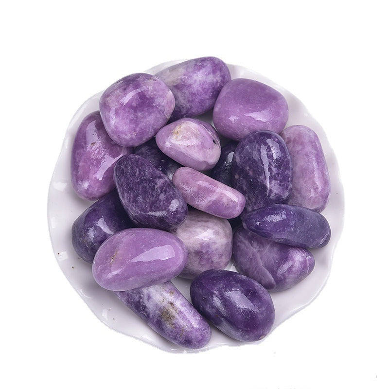 Purple stones on a white plate with a white background
