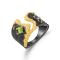 Gold and black ring with gemstones on a white background