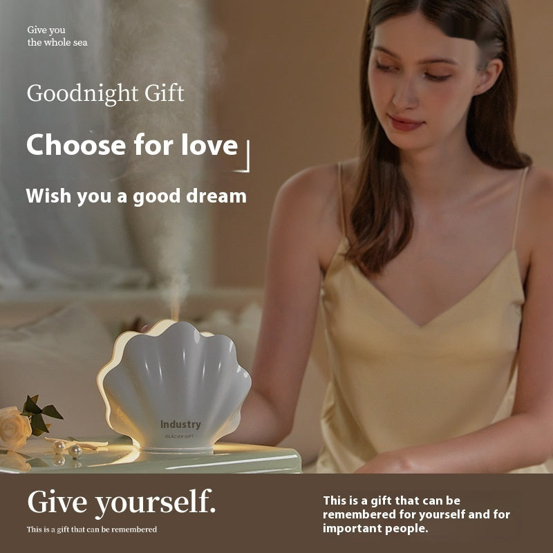 Woman using a shell-shaped diffuser with promotional text about a 'Goodnight Gift' for love and dreams.