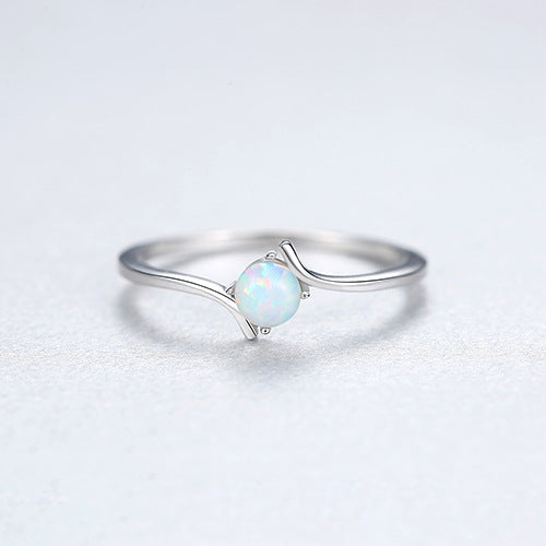 Silver ring with a light blue opal stone on a white background