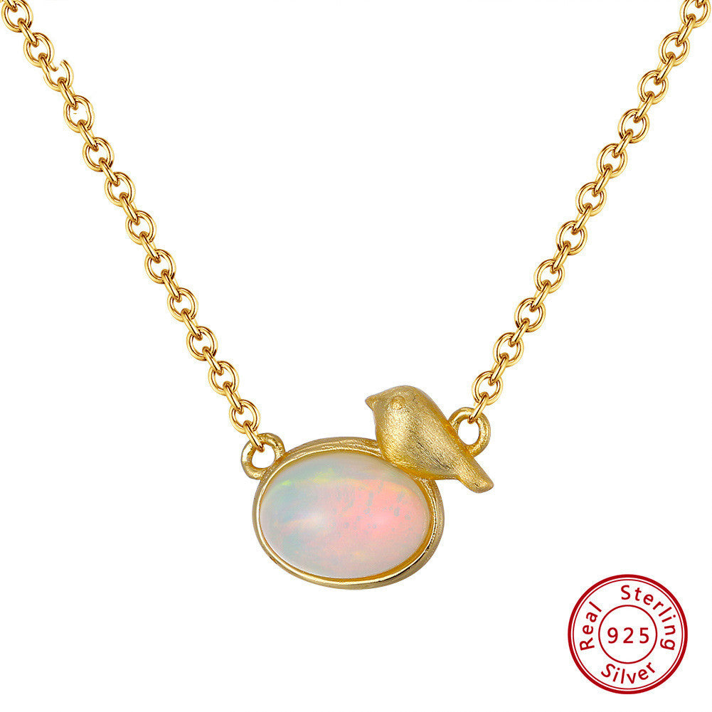 Gold necklace with an opal pendant and a bird design, featuring a 'Real 925 Sterling Silver' stamp.