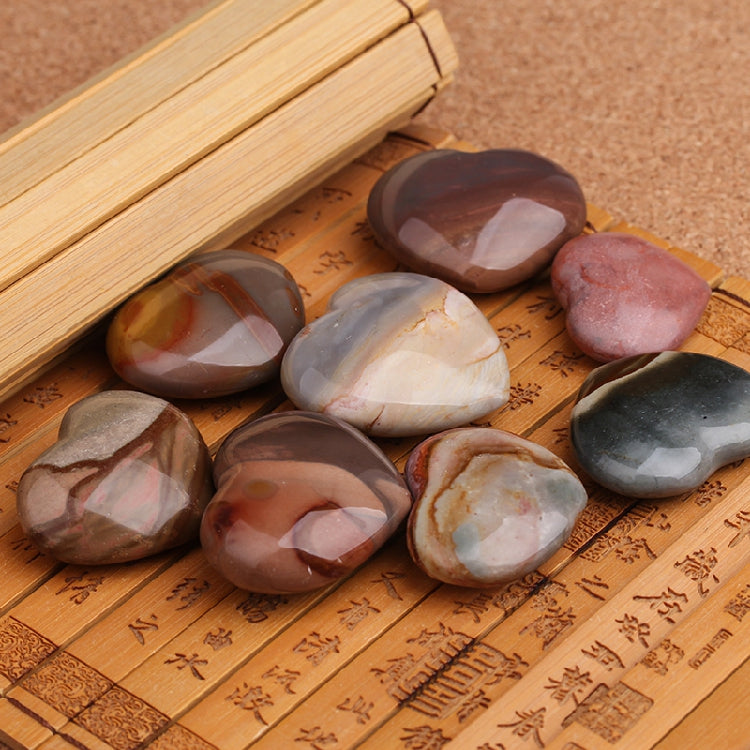 Polished stones on a wooden surface with engraved patterns
