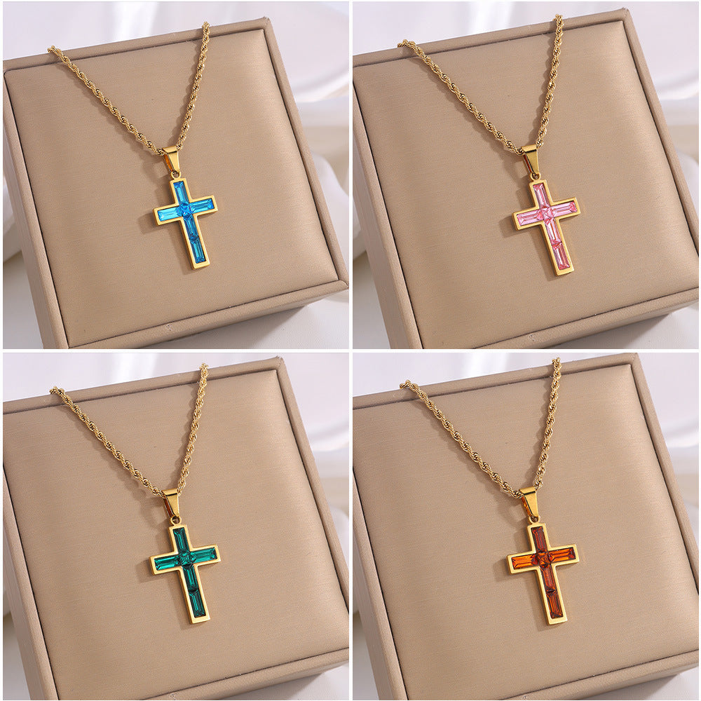 Four different colored cross necklaces on a beige display box.