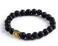 Black beaded bracelet with a gold charm on a white background