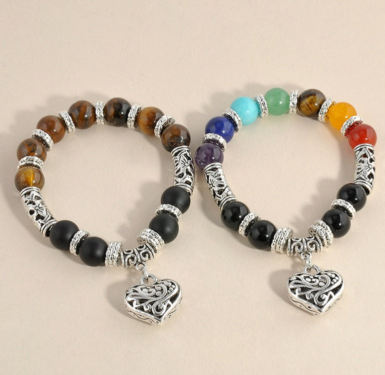Two beaded bracelets with heart charms on a beige background