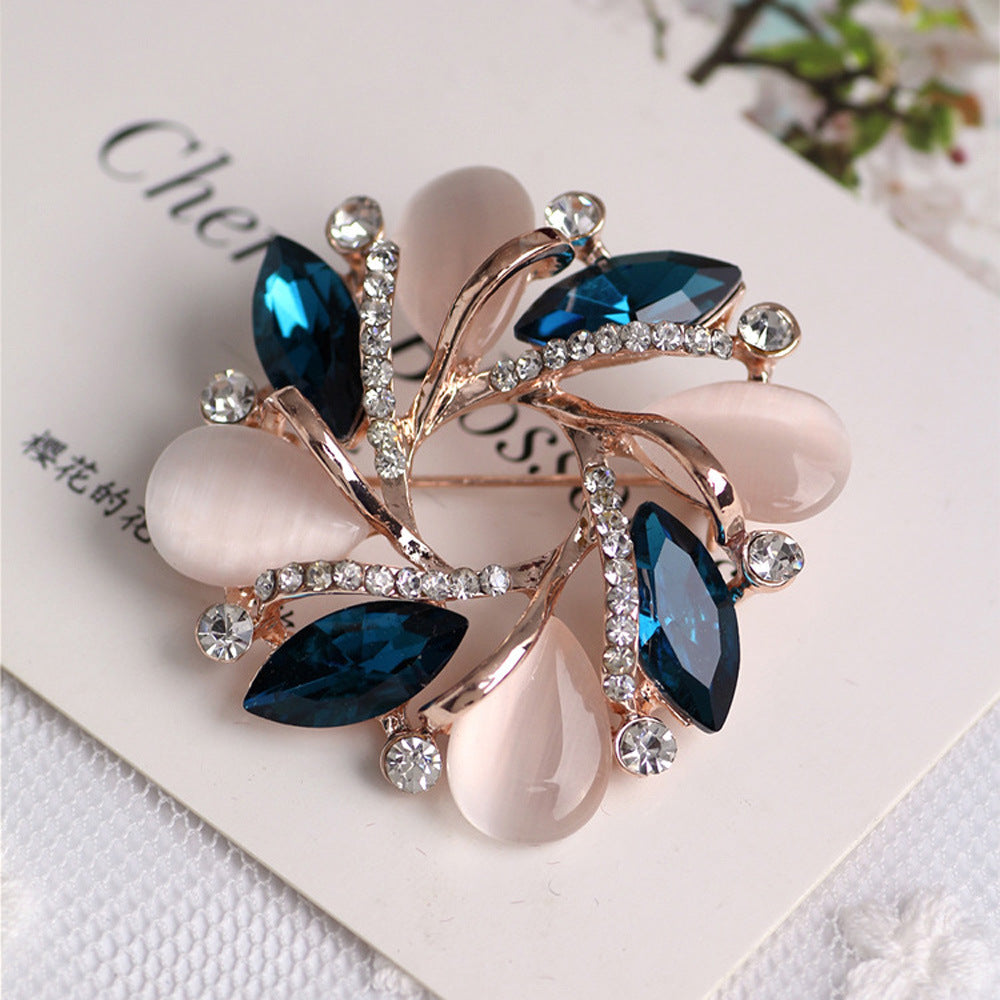Decorative brooch with blue and clear gemstones on a white background