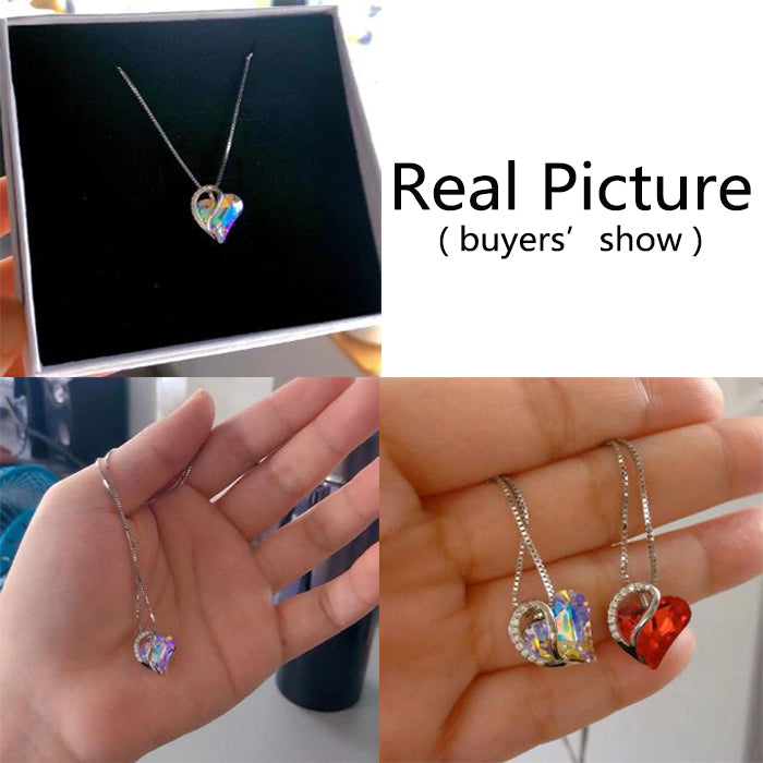 Heart-shaped jewelry set with a necklace and earrings on a black card, held in hands.