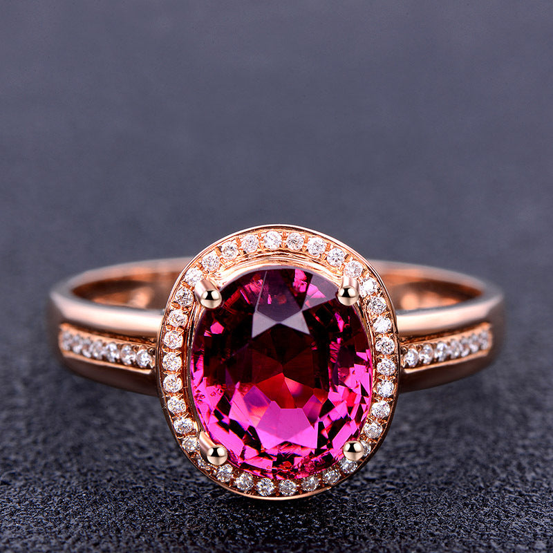 Rose gold ring with a pink gemstone on a dark background