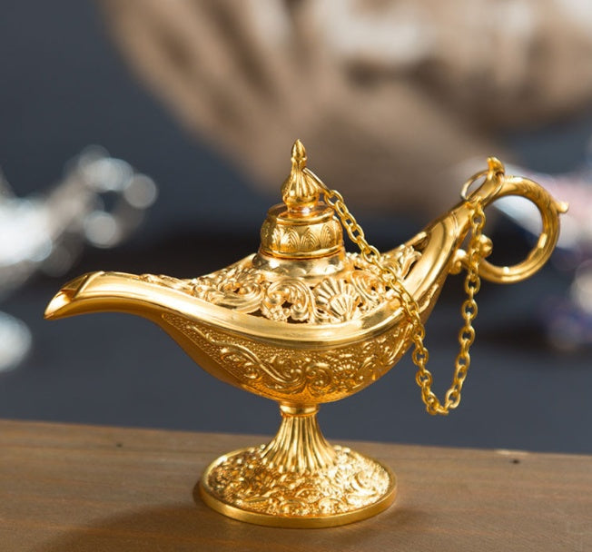Gold genie lamp on a wooden surface with a blurred background