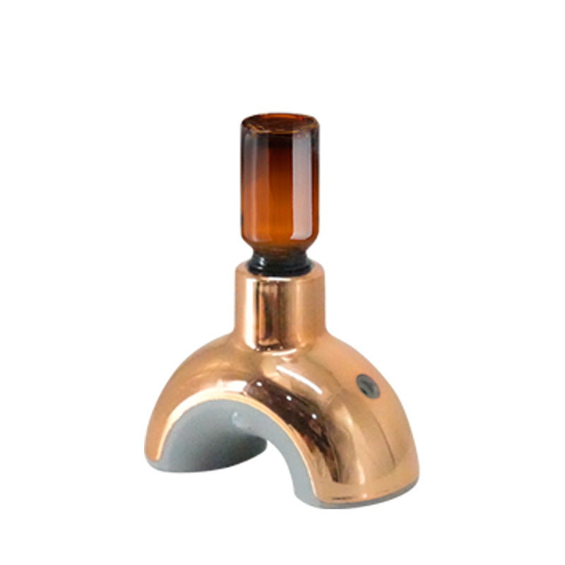 Copper-colored faucet with a glass attachment on a white background