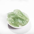 Green crystals in a white bowl on a white background