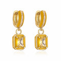 Gold hoop earrings with square citrine stones on a white background