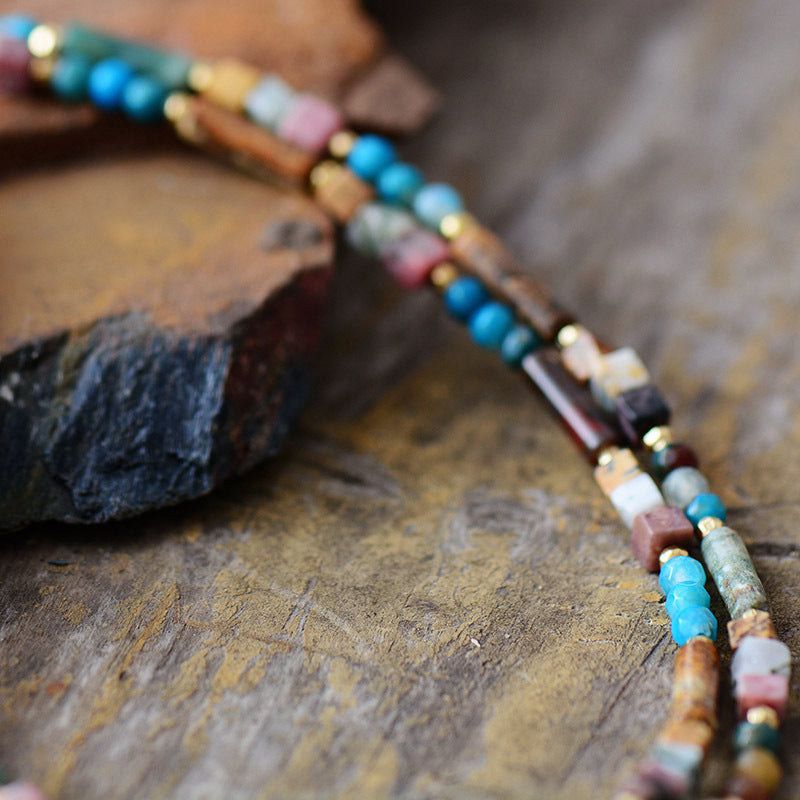 Colorful beaded necklace on a textured stone surface