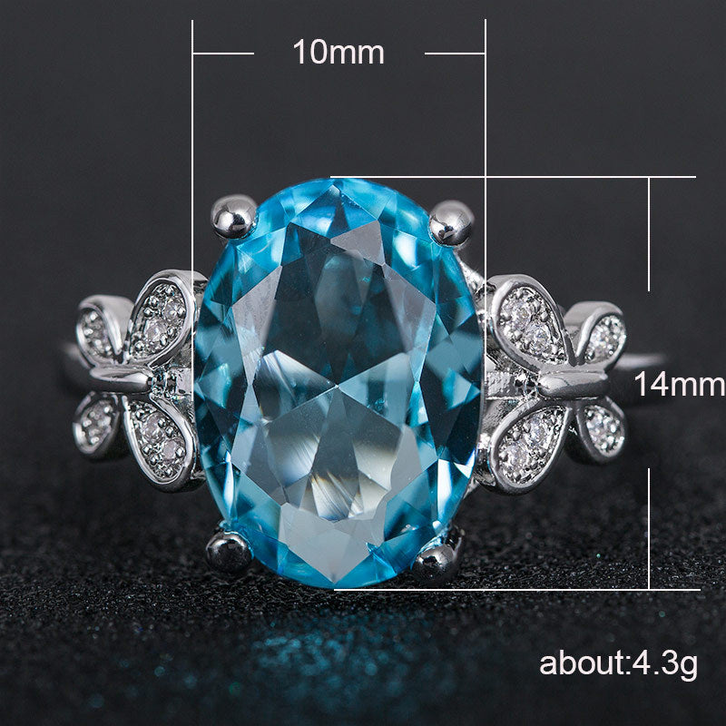 Blue gemstone earring with butterfly design and measurements on a dark background