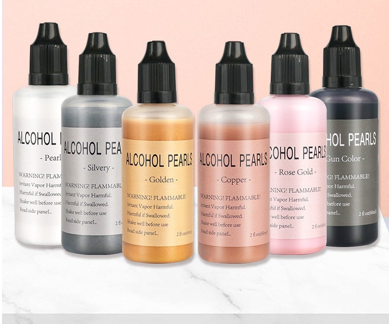 Set of bottles labeled 'Alcohol Pearls' in various colors on a light pink background.