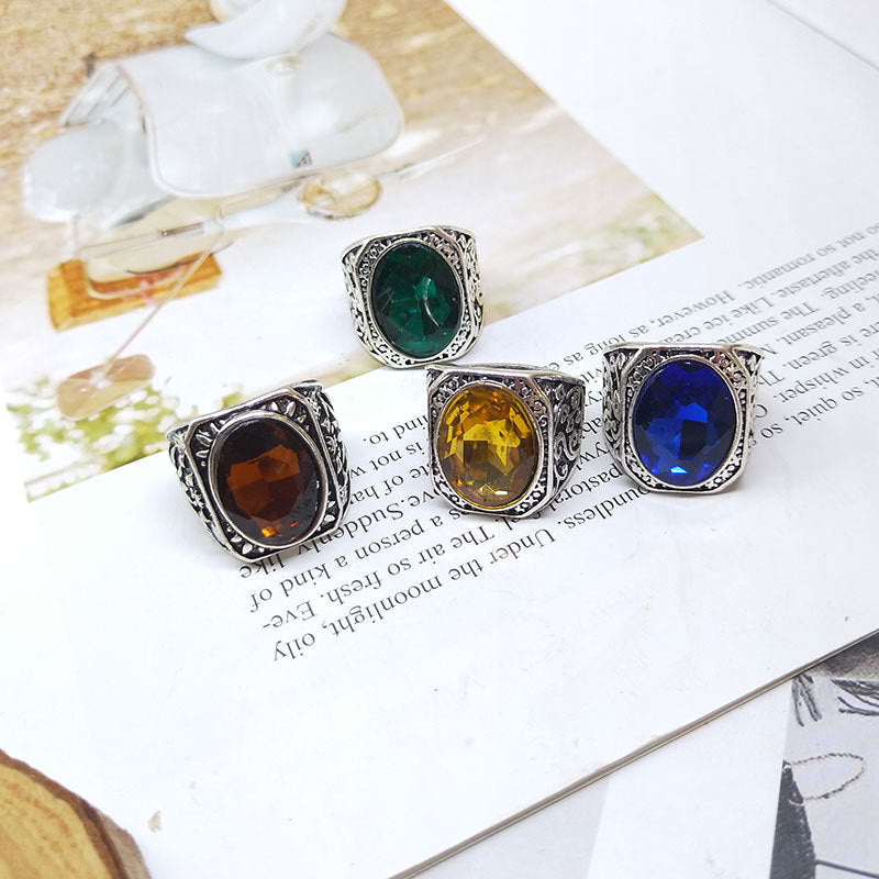 Four gemstone rings with different colored stones on a magazine page.