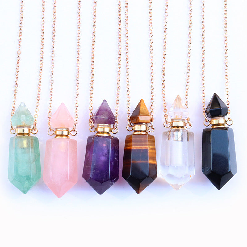 Set of crystal pendant necklaces on gold chains against a white background