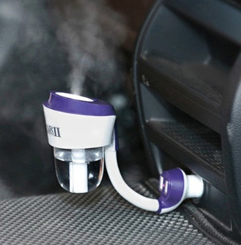Car air freshener with a purple top and white base, emitting steam into a car's interior.