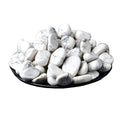 White marbled stones on a black plate with a white background