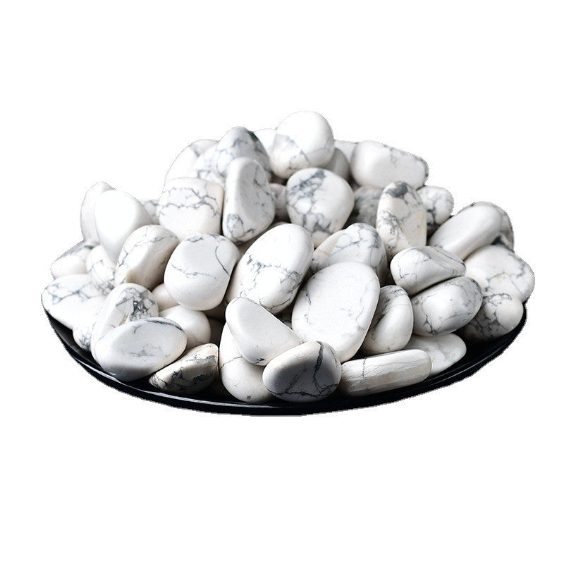 White marbled stones on a black plate with a white background