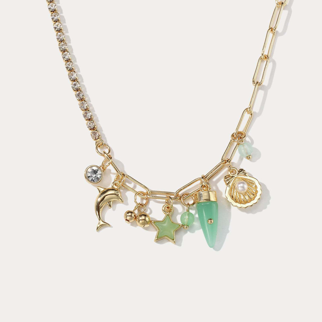 Gold necklace with various charms on a light background